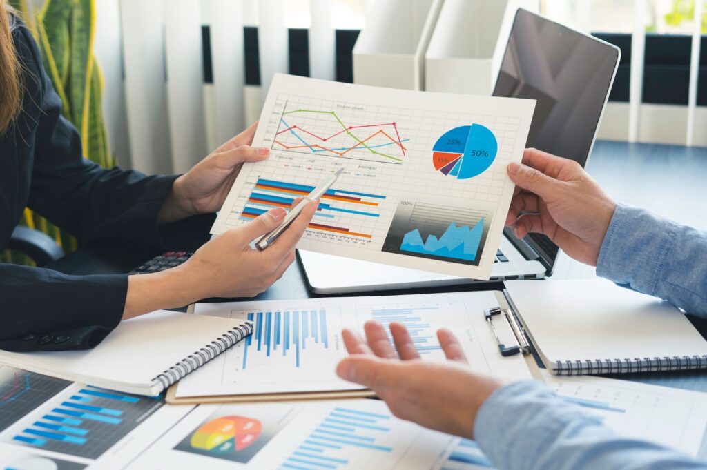 Finance business people or accountants point to the graph to describe the company's income, expenses